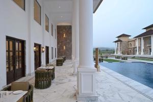 a white building with a pool and a table and chairs at Hari Bagh Jawai in Bijāpur