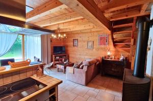 a living room with a couch and a stove at Chalets Shangrila in Saint-Michel-de-Chaillol