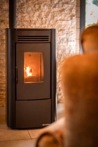 a person sitting in front of a fire oven at "Les Reflets de la Moselotte" - Chalet premium, calme & confort, vue Montagne, proche Centre et Pistes, Parking in La Bresse +67 photos