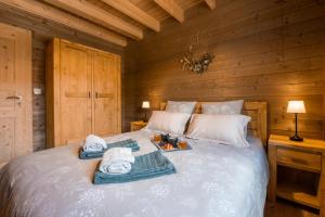 a bedroom with a bed with towels on it at "Les Reflets de la Moselotte" - Chalet premium, calme & confort, vue Montagne, proche Centre et Pistes, Parking in La Bresse