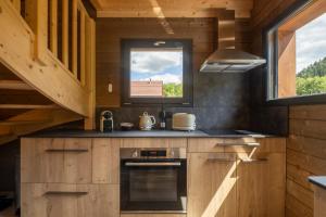 a kitchen with a stove and a window in a cabin at "Les Reflets de la Moselotte" - Chalet premium, calme & confort, vue Montagne, proche Centre et Pistes, Parking in La Bresse
