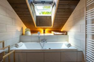 a bathroom with a bath tub with a skylight at "Les Reflets de la Moselotte" - Chalet premium, calme & confort, vue Montagne, proche Centre et Pistes, Parking in La Bresse