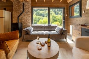 a living room with a table with wine glasses on it at "Les Reflets de la Moselotte" - Chalet premium, calme & confort, vue Montagne, proche Centre et Pistes, Parking in La Bresse