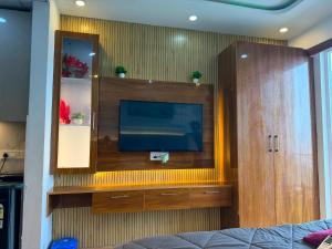 a bedroom with a tv in a wooden cabinet at The heaven stay in Greater Noida