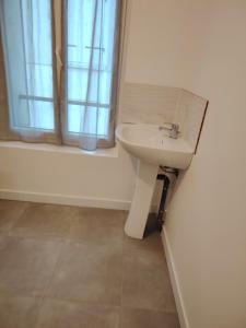 a bathroom with a sink and a window at studio neuf in Beaumont-sur-Oise