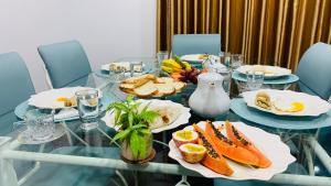 a glass table with plates of food on it at Mist Mountain Hiking Base in Pimbura