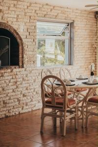 a dining room with a table and chairs and a brick wall at La Melamire On the Rocks Bed & Breakfast in Gansbaai