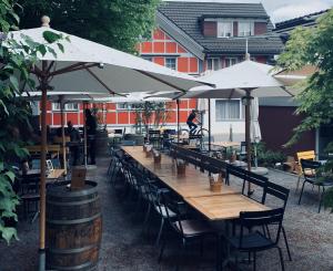 a row of tables and chairs with umbrellas at Traube Restaurant & Hotel in Appenzell