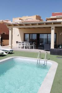 a swimming pool in front of a house at Casa Lily in Caleta De Fuste