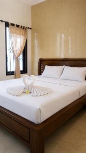 a bed with a heart shaped towel on it at Ambarosed Homestay in Ngaglik