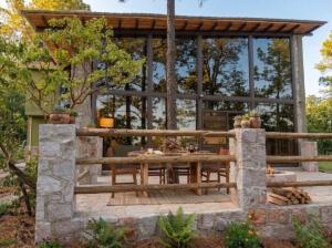 a patio with a wooden table and a large window at Lujo Rustico Lago Cerca Terraza Mascotas in Llano Grande
