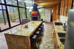 a kitchen with a large island with bar stools at Lujo Rustico Lago Cerca Terraza Mascotas in Llano Grande