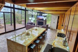 a kitchen with a large table and a living room at Lujo Rustico Lago Cerca Terraza Mascotas in Llano Grande