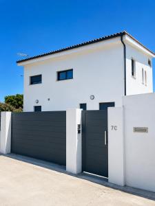 a white house with a black garage door at Blanca Mañana in Ribeira