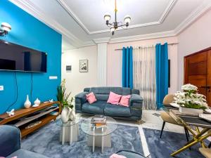 a living room with blue walls and a blue couch at Luxury lita Résidence in Yaoundé