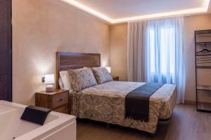 a hotel room with a bed and a bath tub at Artilles Suites in Peniscola