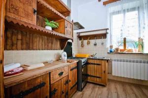 a kitchen with wooden cabinets and a stove top oven at Stary Dwór in Szczawnica