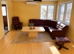 a living room with a brown leather couch and a table at Villa Timsfors i Markaryd in Markaryd