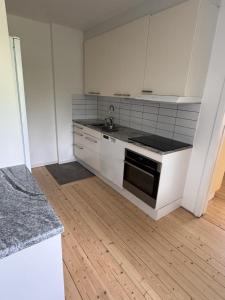 a kitchen with white cabinets and a sink in it at Villa Timsfors i Markaryd in Markaryd