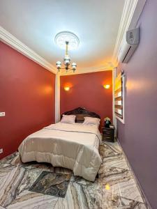 a bedroom with a large bed in a red wall at Luxury lita Résidence in Yaoundé