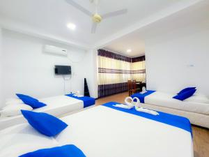 two beds in a room with blue and white at Lion Resort in Polonnaruwa