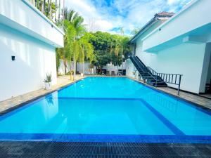 a swimming pool in front of a house with blue water at Lion Resort in Polonnaruwa