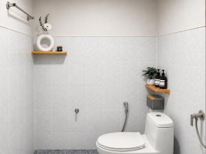 a white bathroom with a toilet and a sink at Ava Beach Pakbara in Ban Pak Ba Ra