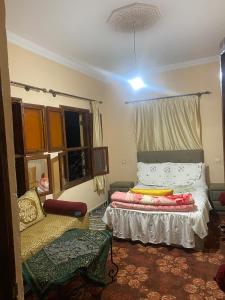a bedroom with a bed and a chair and a window at Aberge Tigmenon Ouirgane in Ouirgane