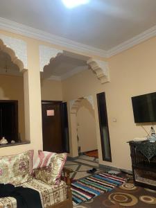a living room with a couch and a flat screen tv at Aberge Tigmenon Ouirgane in Ouirgane