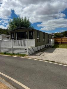 a green and white house with a white fence at Static 34 Newton Abbott Devon TQ126JR in Bickington