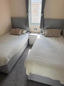 two beds in a small room with a window at Static 34 Newton Abbott Devon TQ126JR in Bickington