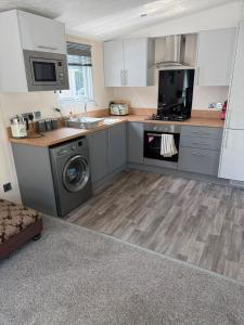 a kitchen with a sink and a washing machine at Static 34 Newton Abbott Devon TQ126JR in Bickington