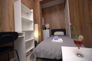a bedroom with a bed and a table with a glass of wine at The Lemon House in Tel Aviv