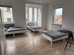 three beds in a room with two windows at Monteursunterkunft - Wohnquartier GbR in Worms