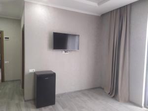 a room with a television on a wall with a trash can at Alped in Zestafoni