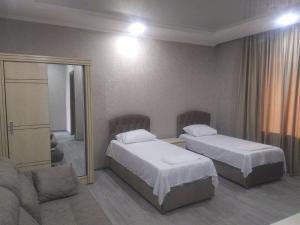 a hotel room with two beds and a mirror at Alped in Zestafoni