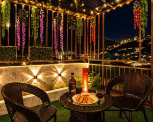 a table with a bottle of wine and two chairs on a balcony at Rizell Alexis in Shimla