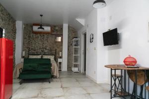 a living room with a green chair and a table at Casa Loma Lola in Molinaseca
