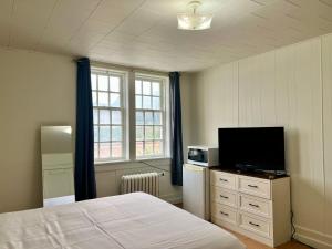 a bedroom with a bed and a flat screen tv at Grand Union Hotel in Coleman