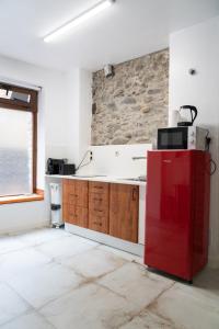 a kitchen with a red refrigerator and a stone wall at Casa Loma Lola in Molinaseca