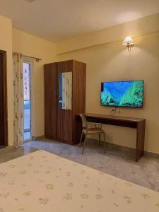 a bedroom with a desk and a tv on the wall at Namma HomeSlice, Balcony Rooms in Brookefield in Bangalore