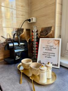 a table with bowls and a plate with a sign at 2-6 Apartman Szeged in Szeged