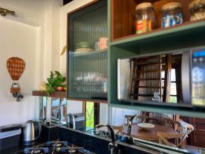 a kitchen with a sink and a counter with a table at Cabana Flamboyant in Praia Grande +45 photos
