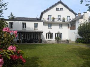 a large white house with a yard at Hôtel de l'Ours in Arette