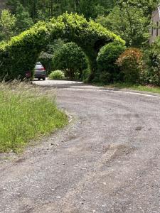 a car driving down a road with an arch in a driveway at chambre dans les bois in Namur