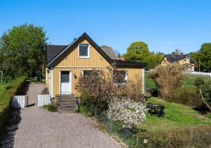 a yellow house with a pathway leading to it at Shared room in a quiet area in Kallinge