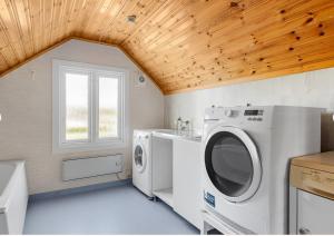 a laundry room with a washer and dryer and a window at Shared room in a quiet area in Kallinge