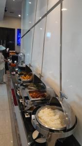 a buffet line with many different types of food at OS Hotel Airport Batam in Batam Center