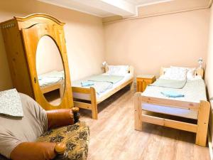 a room with two beds and a chair and a mirror at Agroturystyka Różanka in Nowy Tomyśl