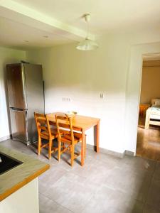 a kitchen with a table and chairs and a refrigerator at Agroturystyka Różanka in Nowy Tomyśl